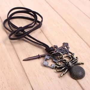 Gros plan de pendentifs araignée, crâne, croix et dague en bronze sur cordon cuir