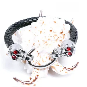 Close-up of punk leather bracelet with silver skulls and red rhinestone eyes detail