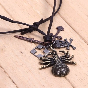 Détail des pendentifs gothiques araignée et crâne sur un collier en cordon de cuir
