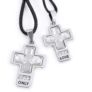 Macro view of silver cross pendants with skull relief and engraved ONLY LOVE text