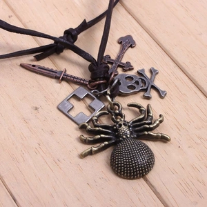 Détail du pendentif araignée gothique et croix en métal sur cordon en cuir brun