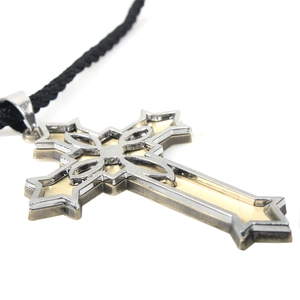 Macro shot of Victorian cross pendant with layered gold and silver filigree detail