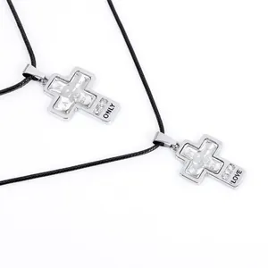 Macro shot of silver cross pendants with skull patterns and engraved ONLY LOVE details
