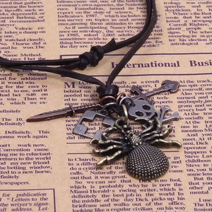 Détail des pendentifs araignée et crâne en bronze antique sur cordon en cuir