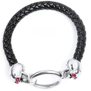 Macro detail of punk woven bracelet featuring silver skulls with red rhinestone eyes