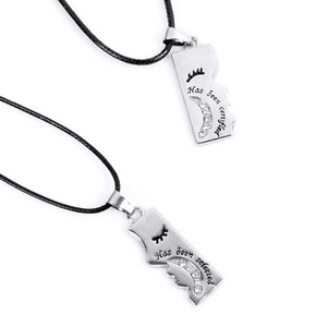 Close-up of interlocking couple necklaces with crescent moon and engraved silver pendants
