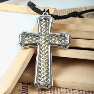 Hollow stainless steel cross pendant with golden honeycomb mesh on black braided rope