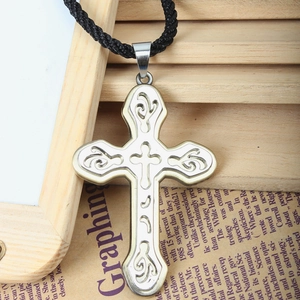 Detalle del colgante de cruz con patrón de nubes huecas y collar de cuerda trenzada