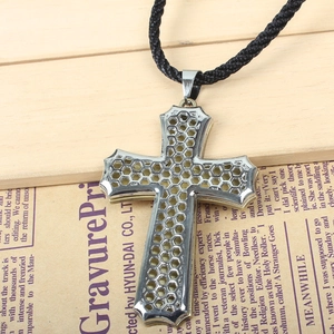 Detailed macro view of silver steel hollow cross pendant with honeycomb texture pattern