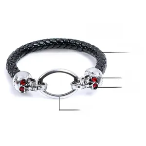 Macro detail of punk leather bracelet featuring steel skulls with red ruby eyes