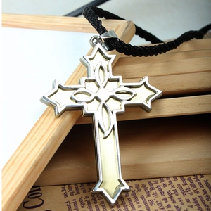 Detail of Victorian style cross pendant with luminous inlay and black braided cord necklace