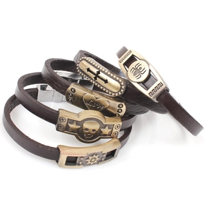 Detail of five punk leather bracelets featuring skull, cross, and heart alloy charms