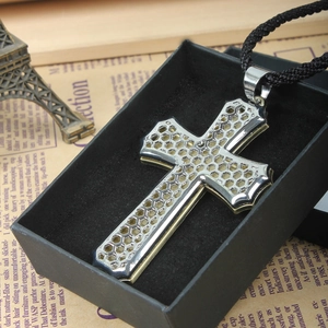 Macro shot of two-tone hollow honeycomb cross pendant in a black gift box