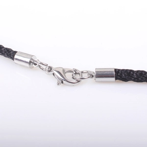 Macro detail of silver lobster clasp and black woven cord for double cross necklace