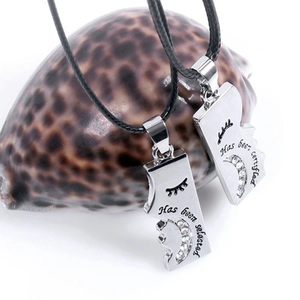 Close-up of puzzle piece pendant necklaces with rhinestones on a seashell background