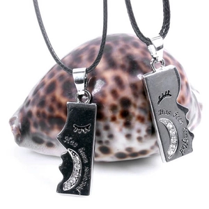 Detail of couple pendants with moon motifs and engraved text on black wax rope