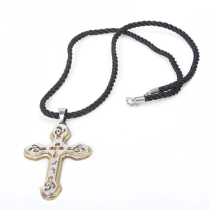 Detalle del colgante de cruz bicolor oro y plata con cordón de nailon negro trenzado