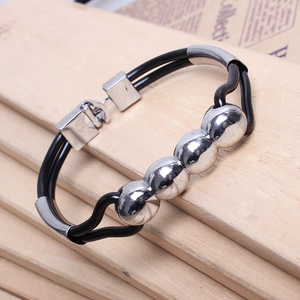 Detail of a minimalist black double-cord bracelet with four polished silver metal beads