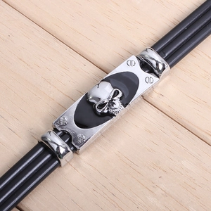 Detail of punk braided leather bracelet with silver skull metal plate and screws