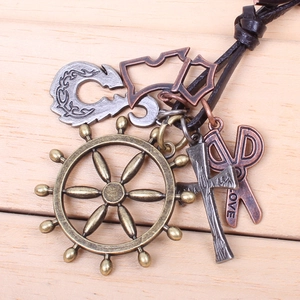 Detail of vintage ship wheel and scissors pendants with engraved LOVE on a leather cord