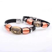 Detail of couple leather bracelets with heart-embossed gold beads and silver buckles