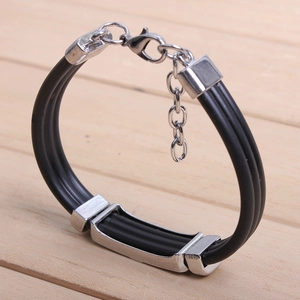 Detail view of silver punk skull charm on black woven leather cord bracelet with clasp