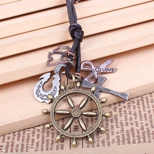 Detail of vintage ship wheel pendant with leather cord and industrial charms