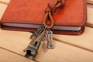 Close-up of vintage leather keychain with Eiffel Tower and bronze alloy charms