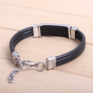 Close-up of punk style braided leather bracelet with silver skull charm and metal clasp