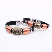 Close-up of leather couple bracelets featuring Kiss Me and Hug Me engraved metal beads