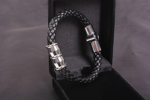 Detail of black braided leather men's bracelet with silver magnetic metal clasp