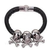 Macro view of punk men's leather bracelet with silver skull charms and magnetic clasp