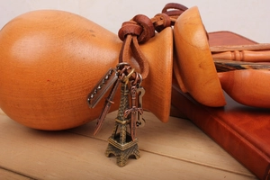 Detail of vintage leather necklace with Eiffel Tower, sword, and key bronze pendants