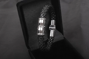 Close-up of black punk snake pattern woven leather bracelet with silver magnetic buckle