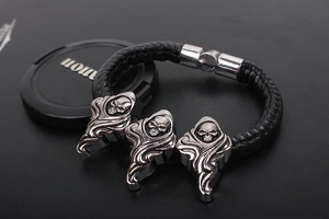 Detail of punk braided leather bracelet with three metal skulls and magnetic closure