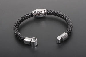 Detail of men's braided leather bracelet featuring a silver lightning bolt bead and magnetic clasp