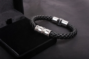 Close-up of men's black braided leather bracelet with silver magnetic metal clasp