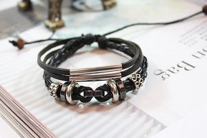 Close-up of multilayer braided leather bracelet with vintage silver charms and metal beads