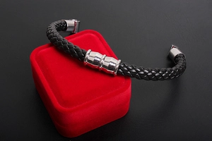 Close-up of black braided leather men's bracelet with silver magnetic metal clasp