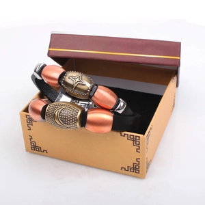 Detailed close-up of retro leather couple bracelet with star and moon metal charms in a gift box