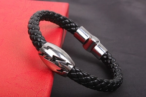 Close-up of black braided leather bracelet with silver magnetic lightning bolt clasp