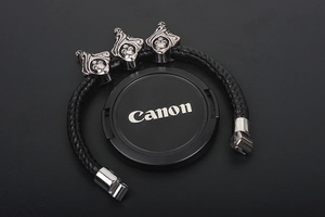 Detail of a men's punk leather bracelet with silver skull charms and braided texture