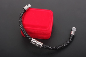 Macro shot of men's black braided leather bracelet with silver magnetic closures
