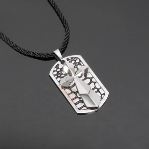 Silver cross necklace pendant with textured metal tag on black braided cord