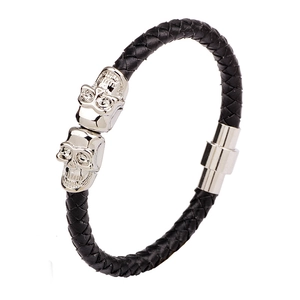 Braided black leather bracelet featuring silver metal skulls and magnetic buckle