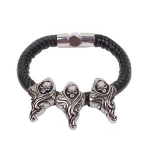 Punk style black braided leather bracelet featuring three silver metal skull charms and magnetic clasp