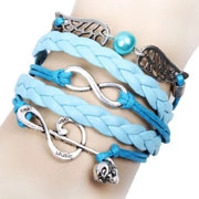 Détail du bracelet en cuir tressé bleu avec ailes d'ange et breloques musique