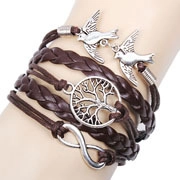 Détail d'un bracelet en cuir tressé avec pendentifs arbre de vie et petits oiseaux