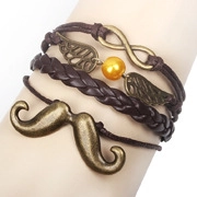 Détail d'un bracelet multicouche en cuir PU avec breloques en bronze et signe infini