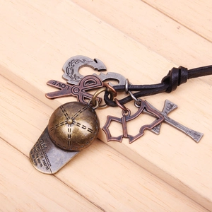 Close-up of vintage bronze baseball hat and multiple charms on black cord necklace